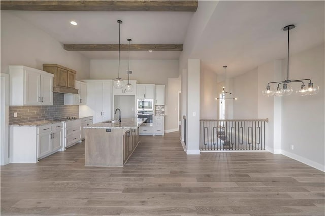 kitchen with tasteful backsplash, beamed ceiling, stainless steel appliances, light wood-type flooring, and a sink