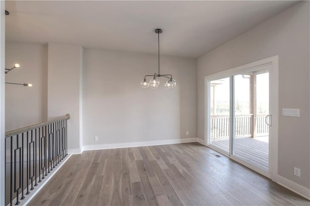 unfurnished room featuring visible vents, baseboards, and wood finished floors