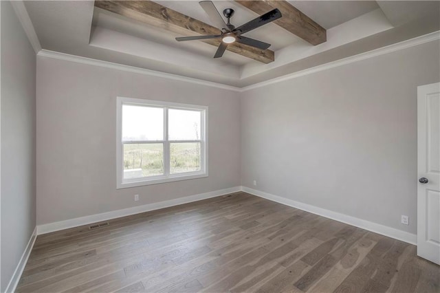 unfurnished room with wood finished floors, a raised ceiling, and baseboards