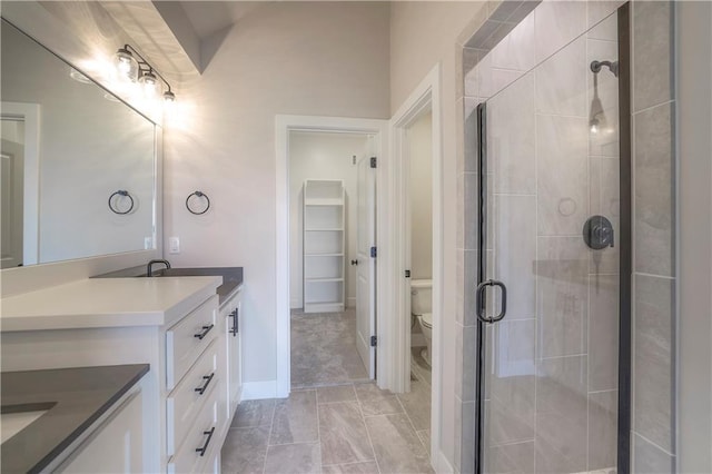 bathroom featuring a stall shower, vanity, and toilet