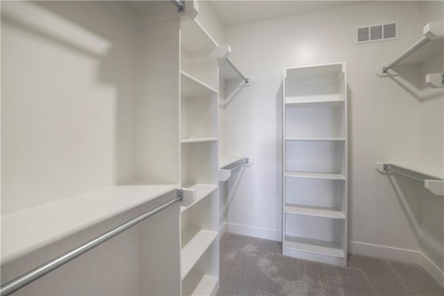 walk in closet with visible vents and dark carpet