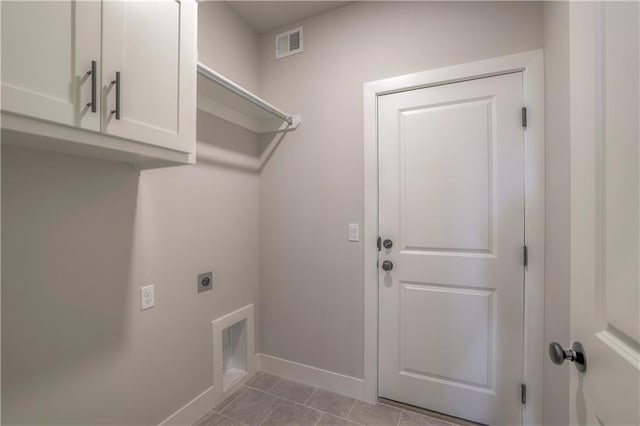 clothes washing area featuring visible vents, baseboards, cabinet space, tile patterned floors, and electric dryer hookup