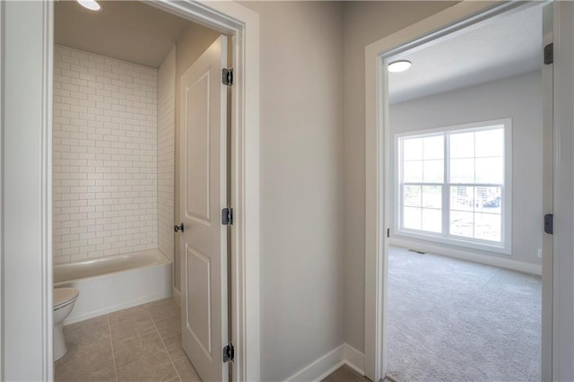 full bath featuring tile patterned flooring, baseboards, shower / tub combination, and toilet