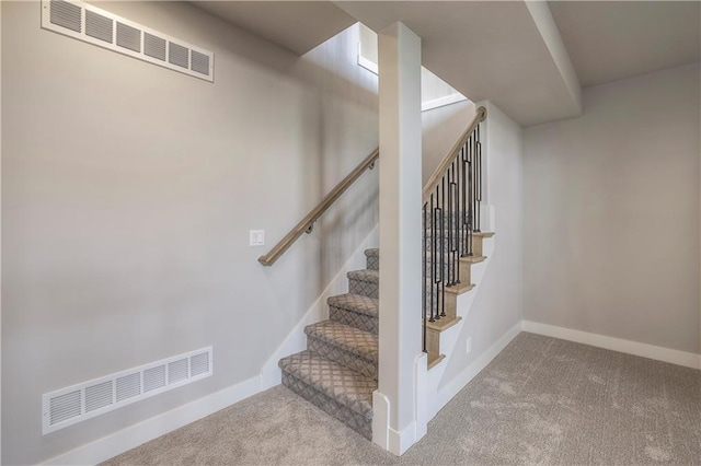 staircase with carpet floors, visible vents, and baseboards