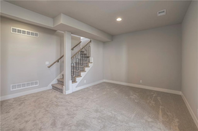 finished basement featuring stairway, baseboards, visible vents, and recessed lighting