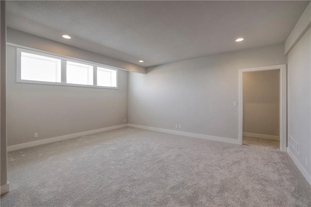 carpeted spare room with visible vents, baseboards, and recessed lighting