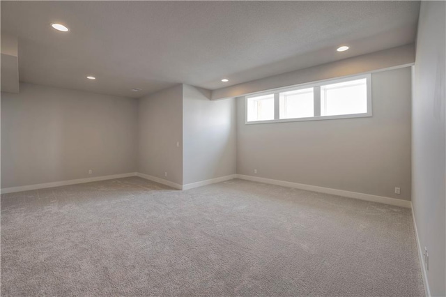 carpeted spare room featuring baseboards and recessed lighting