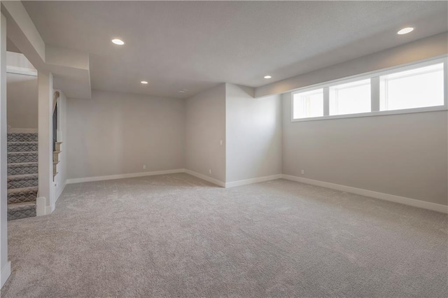 basement featuring carpet floors, recessed lighting, stairway, and baseboards