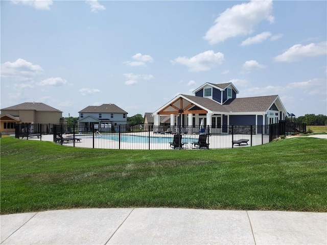 community pool with a yard, a patio, and fence