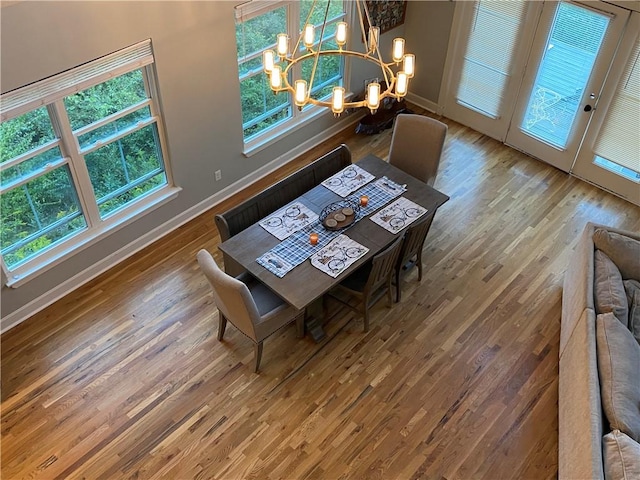 dining room featuring wood-type flooring and an inviting chandelier