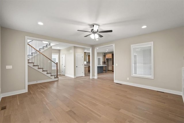 unfurnished living room with ceiling fan and light wood-type flooring