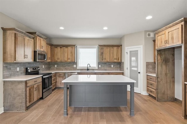 kitchen featuring sink, stainless steel appliances, a center island, and a breakfast bar