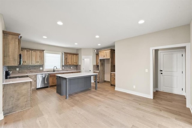 kitchen featuring tasteful backsplash, light hardwood / wood-style flooring, stainless steel appliances, and a center island