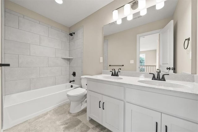 full bathroom with tiled shower / bath, vanity, and toilet