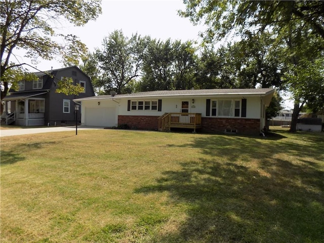 view of front of home featuring a gambrel roof, driveway, a front yard, an attached garage, and brick siding