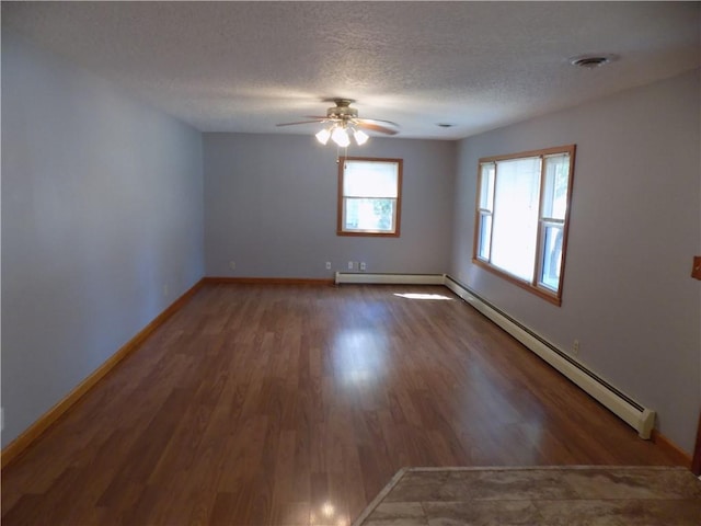 spare room with a textured ceiling, dark hardwood / wood-style floors, ceiling fan, and a baseboard radiator