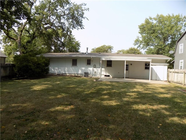 back of property featuring an attached carport, a patio area, fence, and a lawn