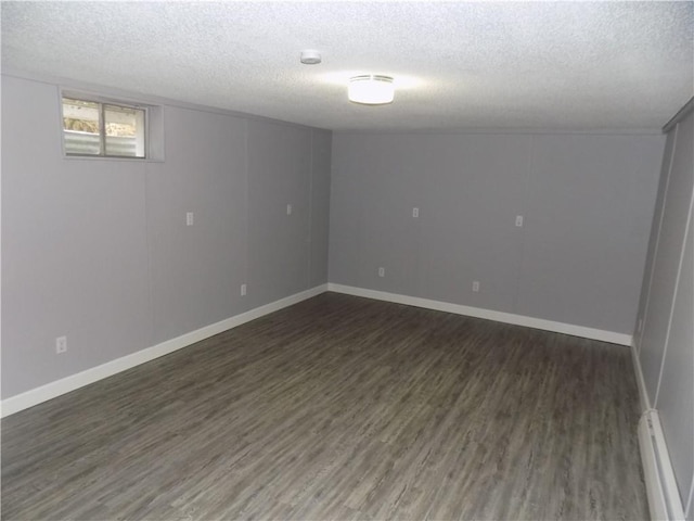 basement featuring a textured ceiling and dark hardwood / wood-style floors