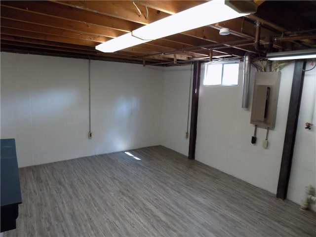 basement with electric panel and wood finished floors