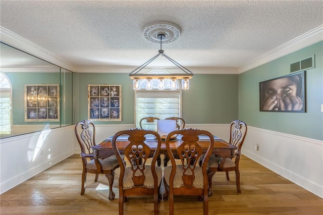 dining space with crown molding, a healthy amount of sunlight, and hardwood / wood-style flooring