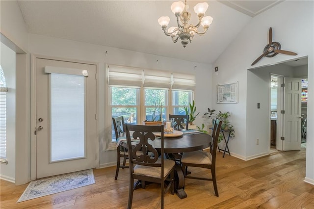 dining space with light hardwood / wood-style floors, a notable chandelier, and vaulted ceiling