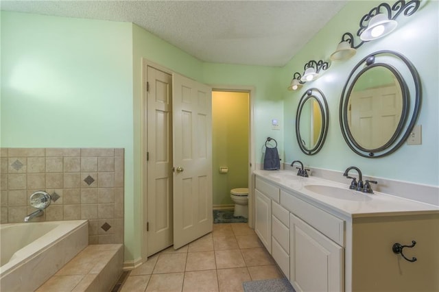 bathroom with a textured ceiling, toilet, a bath, vanity, and tile patterned flooring