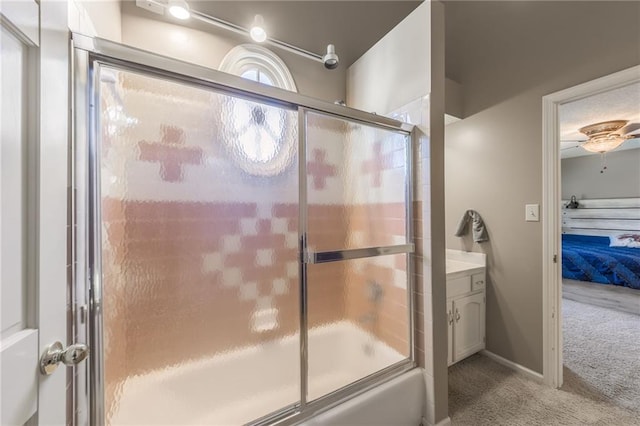 bathroom featuring vanity, enclosed tub / shower combo, and ceiling fan