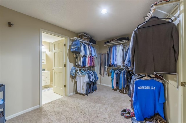 spacious closet featuring light colored carpet