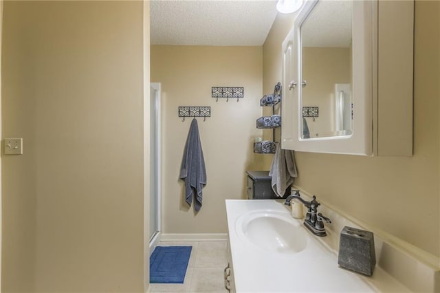 bathroom with vanity, tile patterned floors, a textured ceiling, and an enclosed shower