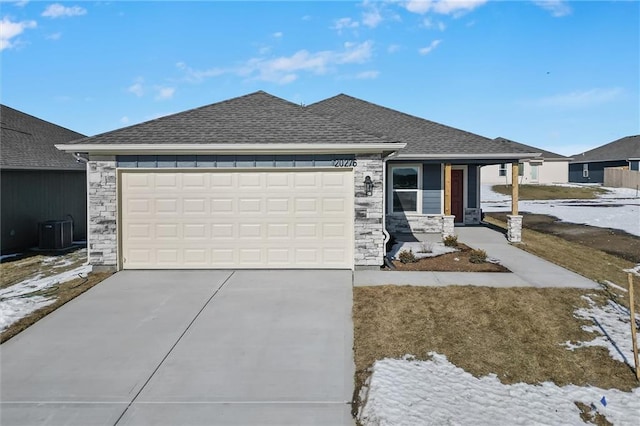 view of front of property with a garage, a porch, and central air condition unit