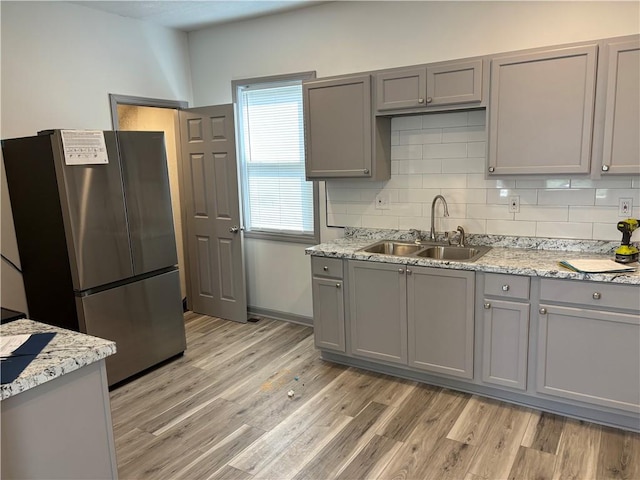 kitchen featuring light wood-type flooring, a wealth of natural light, and stainless steel refrigerator