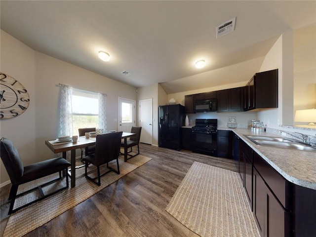 kitchen with dark wood-type flooring, black appliances, dark brown cabinetry, and sink