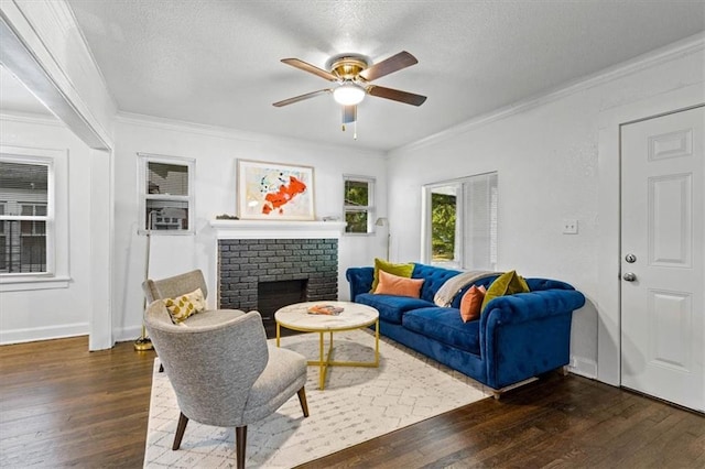 living room featuring a brick fireplace, dark hardwood / wood-style floors, crown molding, and ceiling fan