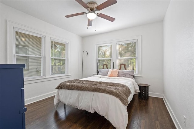 bedroom featuring ceiling fan, dark hardwood / wood-style flooring, and multiple windows