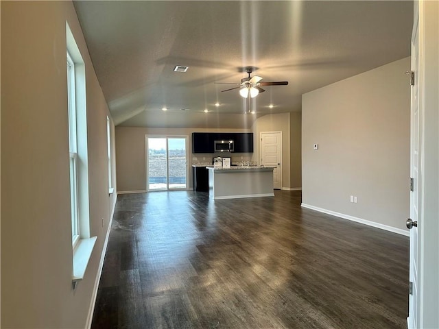 unfurnished living room with dark wood-type flooring and ceiling fan