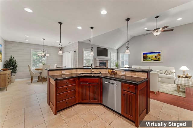 kitchen with ceiling fan with notable chandelier, sink, a kitchen island with sink, and vaulted ceiling