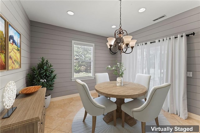 tiled dining area with wooden walls and a chandelier