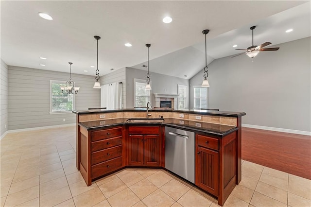 kitchen featuring a center island with sink, sink, ceiling fan with notable chandelier, and lofted ceiling