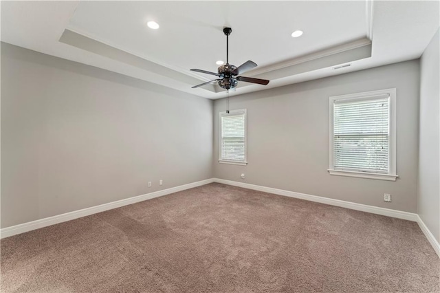 unfurnished room with ceiling fan, ornamental molding, carpet floors, and a tray ceiling