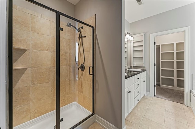 bathroom with tile patterned floors, a shower with door, and vanity