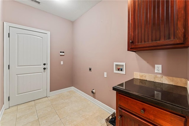 washroom with washer hookup, hookup for an electric dryer, cabinets, and light tile patterned flooring