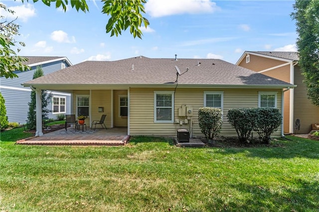 rear view of property featuring a yard and a patio area