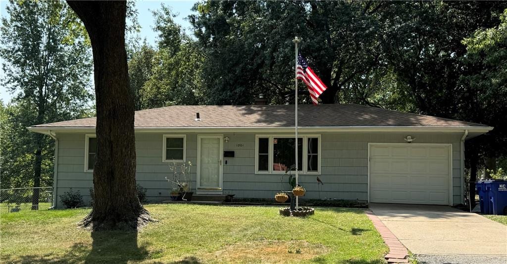 ranch-style home featuring a garage and a front lawn