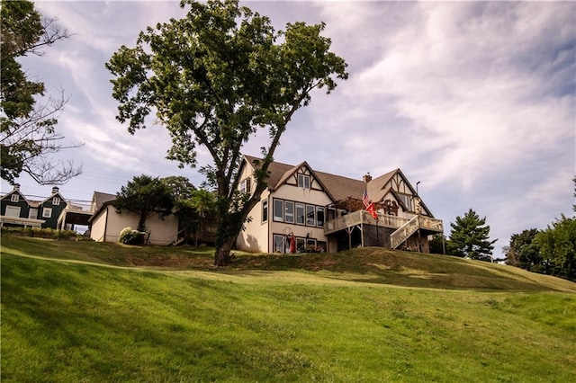 tudor-style house with a deck and a front lawn