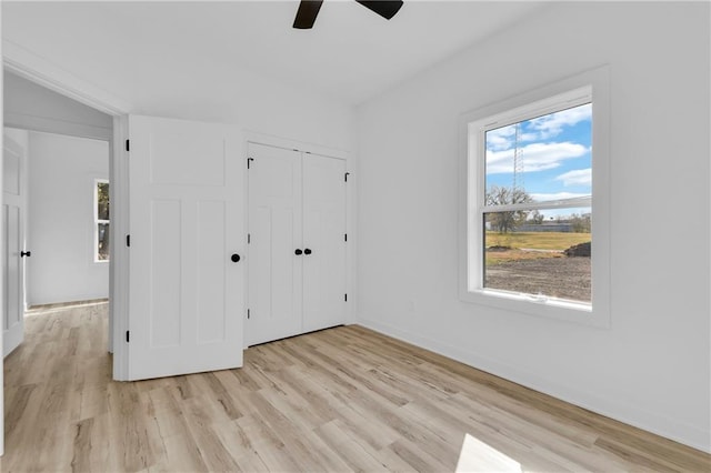 unfurnished bedroom featuring a closet, ceiling fan, and light hardwood / wood-style flooring