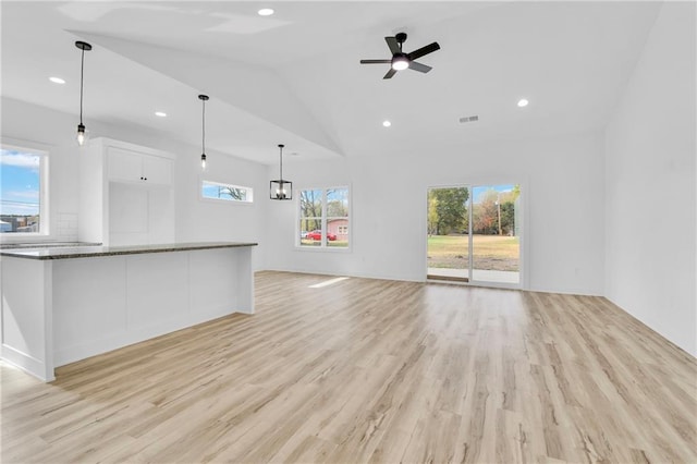 unfurnished living room featuring vaulted ceiling, light hardwood / wood-style flooring, and ceiling fan