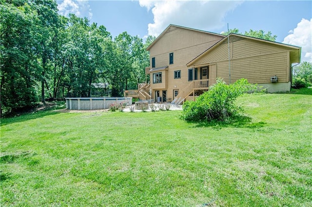 rear view of property with a pool side deck and a yard