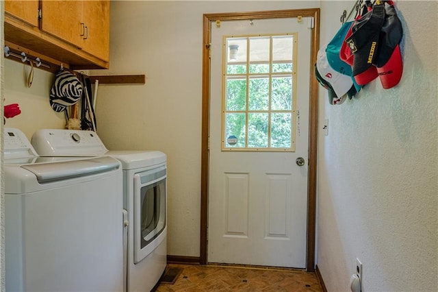 washroom featuring cabinets, washer and clothes dryer, and light parquet flooring