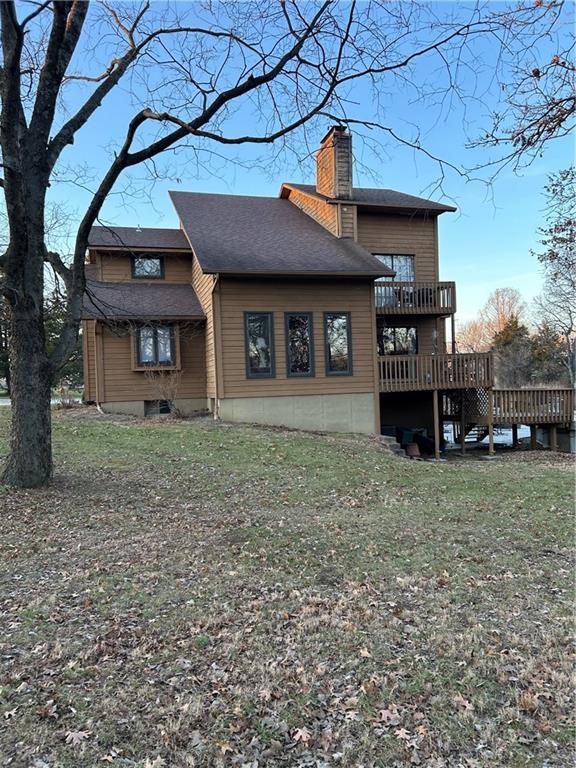 back of property with a lawn and a wooden deck