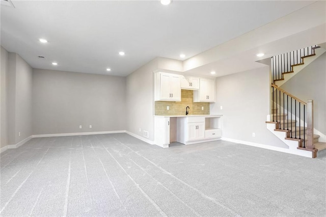 unfurnished living room with sink and light carpet